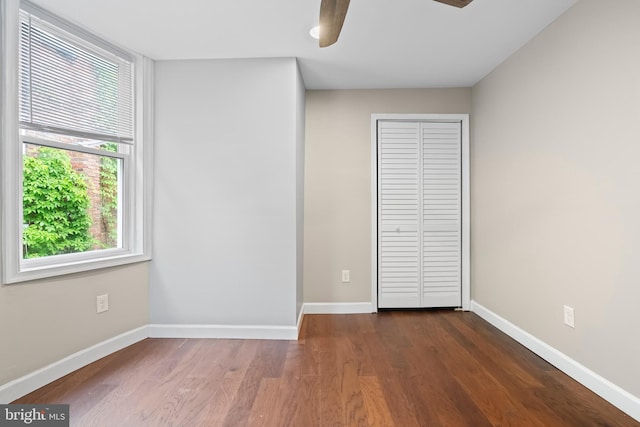 unfurnished bedroom with ceiling fan and dark hardwood / wood-style flooring