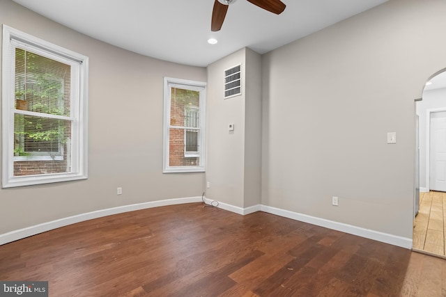 empty room with ceiling fan and dark wood-type flooring