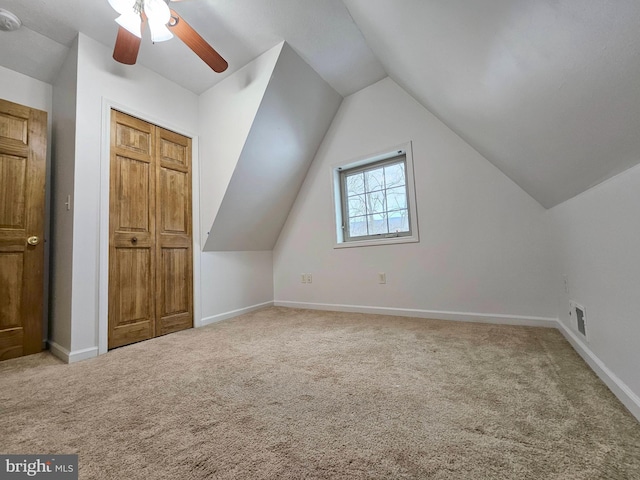 additional living space featuring ceiling fan, light colored carpet, and lofted ceiling