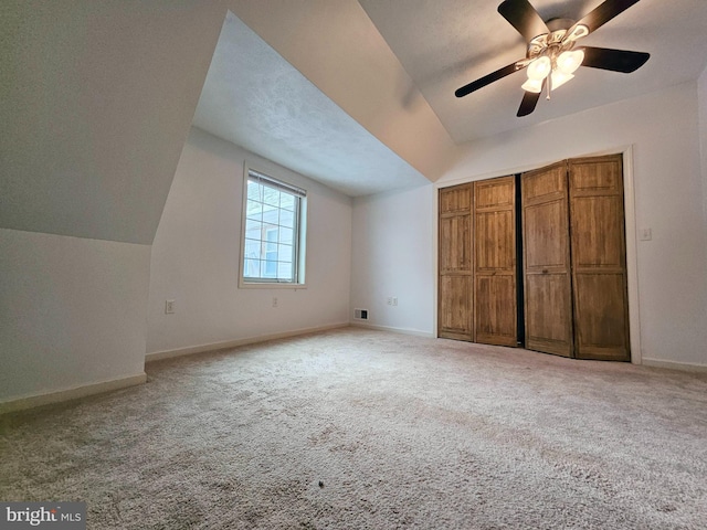 additional living space with ceiling fan, light carpet, and vaulted ceiling