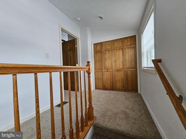 corridor with light carpet and lofted ceiling