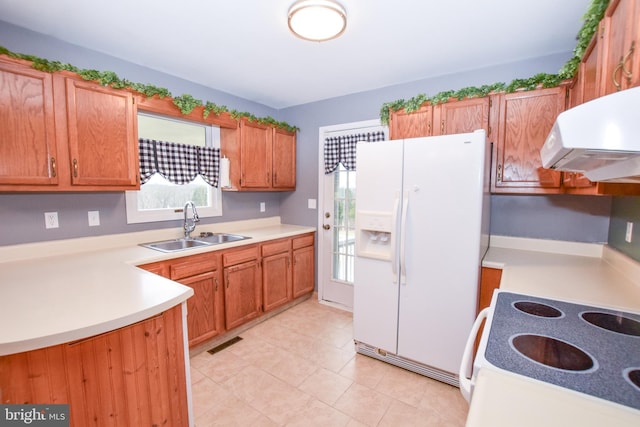 kitchen with sink, stove, and white refrigerator with ice dispenser