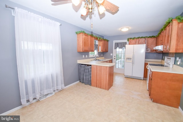 kitchen featuring ventilation hood, ceiling fan, sink, white refrigerator with ice dispenser, and range with electric stovetop