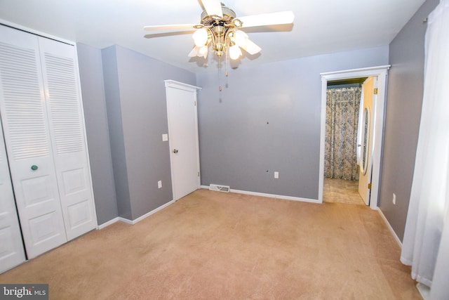 unfurnished bedroom with ceiling fan, a closet, and light colored carpet