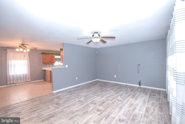 unfurnished living room featuring ceiling fan and light hardwood / wood-style floors