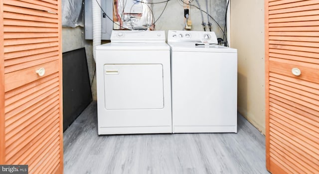 laundry room with washing machine and dryer and light hardwood / wood-style floors