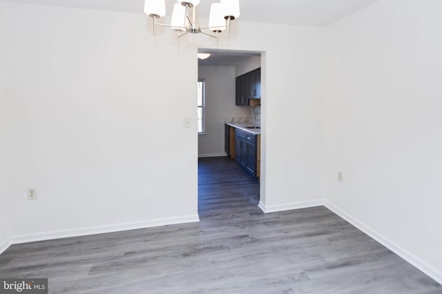 unfurnished dining area featuring dark hardwood / wood-style flooring and an inviting chandelier