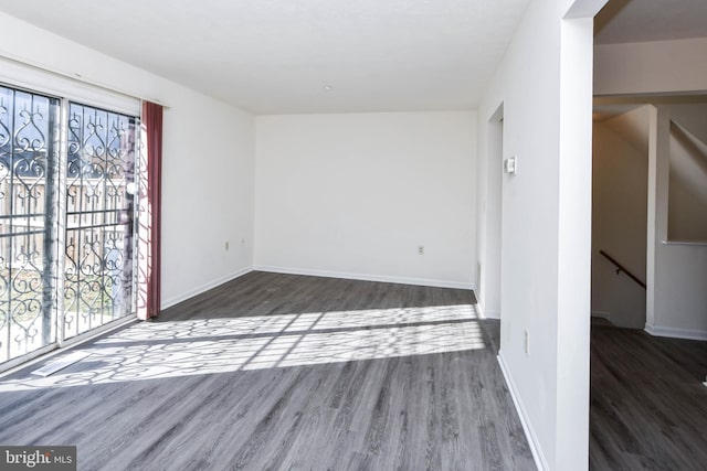 unfurnished room with dark hardwood / wood-style flooring