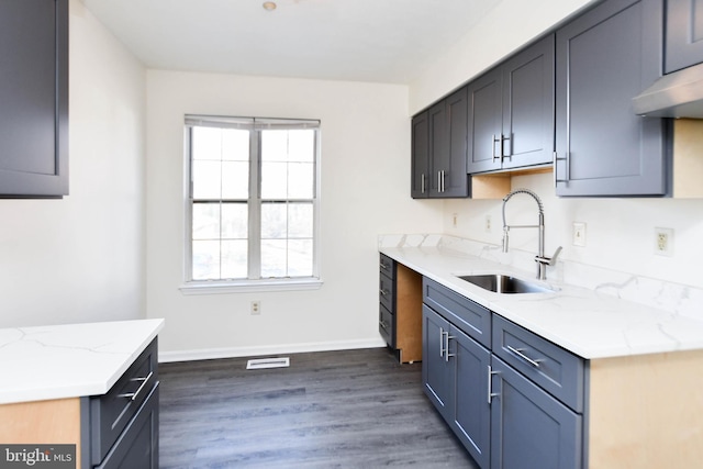 kitchen with dark hardwood / wood-style floors, sink, and light stone counters