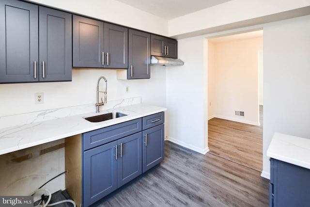 kitchen with sink, dark wood-type flooring, and light stone countertops