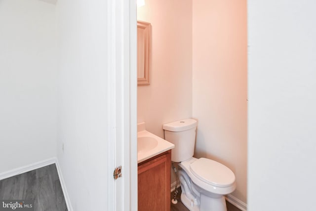 bathroom with vanity, toilet, and hardwood / wood-style floors