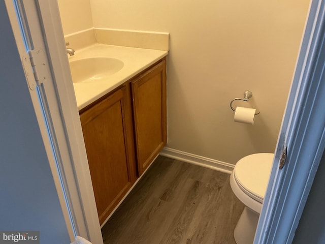 bathroom featuring vanity, hardwood / wood-style floors, and toilet