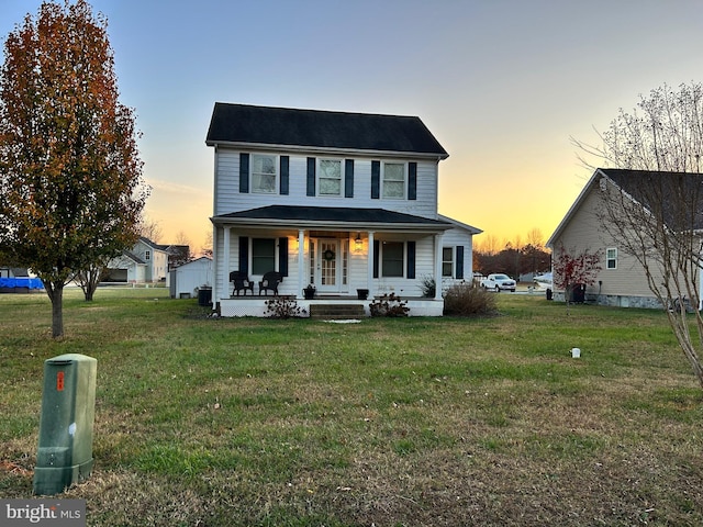 view of front facade with a lawn and covered porch