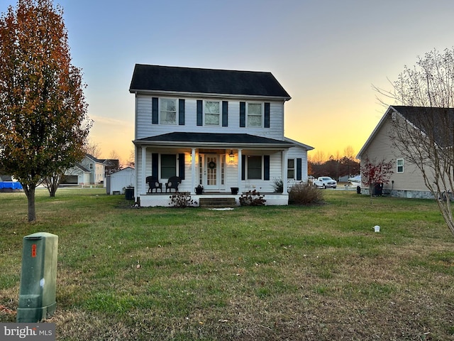 view of front of property with a porch and a lawn