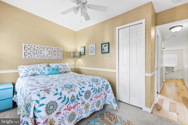 bedroom featuring ceiling fan, cooling unit, light hardwood / wood-style flooring, and a closet