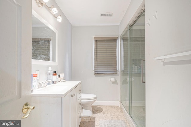 bathroom featuring toilet, an enclosed shower, and vanity