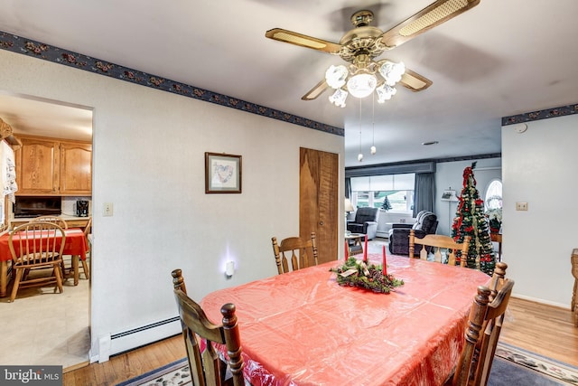 dining room featuring light hardwood / wood-style floors, baseboard heating, and ceiling fan