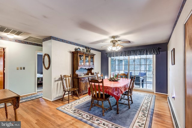 dining area with ceiling fan, a baseboard radiator, and light wood-type flooring