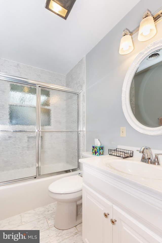 full bathroom featuring vanity, toilet, and bath / shower combo with glass door