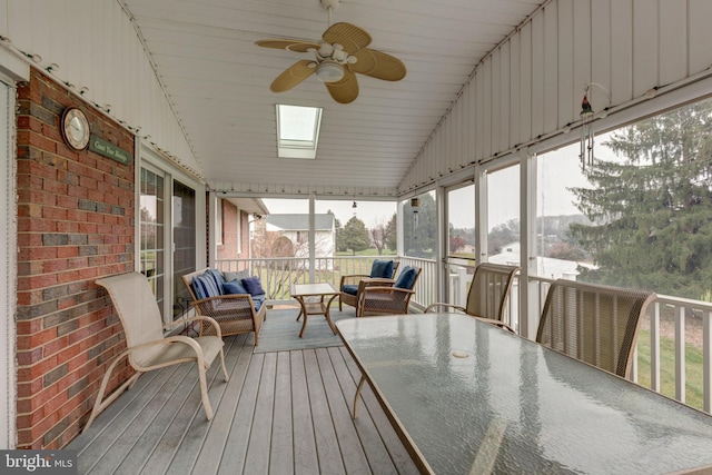 sunroom with ceiling fan, lofted ceiling with skylight, and wooden ceiling