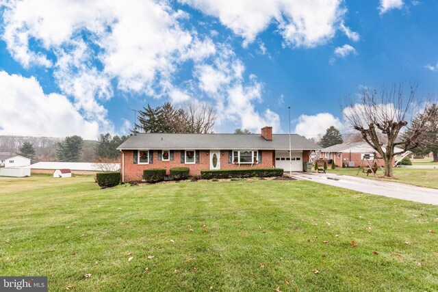 ranch-style home with a garage and a front lawn