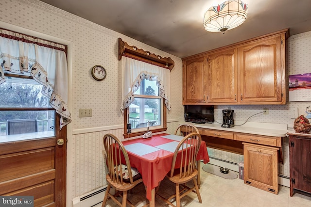 dining area with built in desk and a baseboard radiator