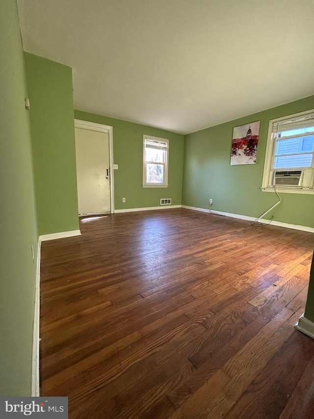 unfurnished room with cooling unit and dark wood-type flooring