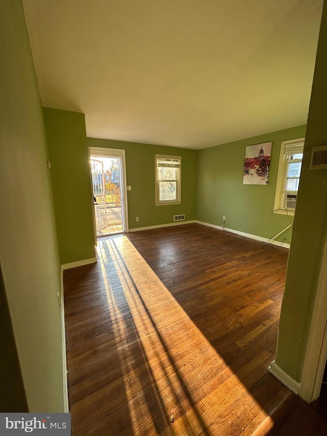 unfurnished living room featuring dark hardwood / wood-style flooring and cooling unit