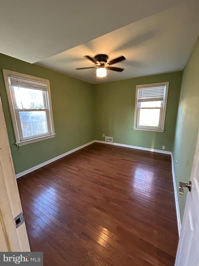 unfurnished room with ceiling fan and dark hardwood / wood-style floors