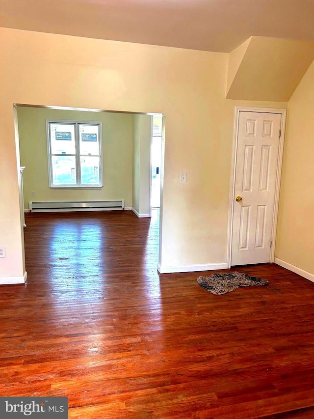 unfurnished room with dark hardwood / wood-style flooring and a baseboard heating unit