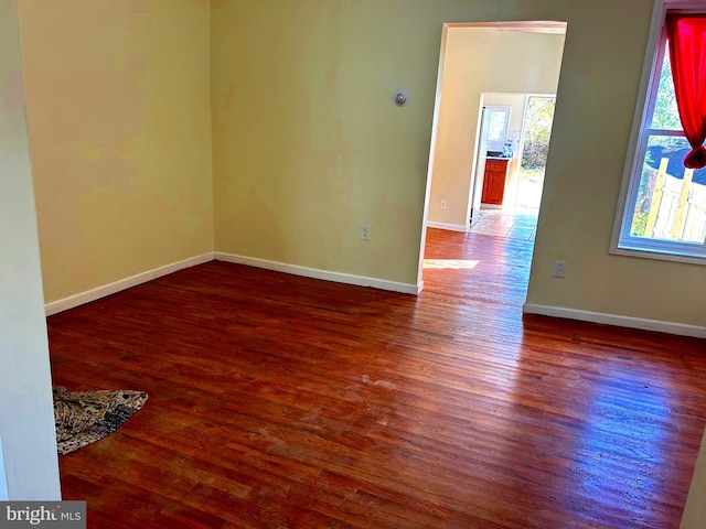 empty room with dark hardwood / wood-style flooring