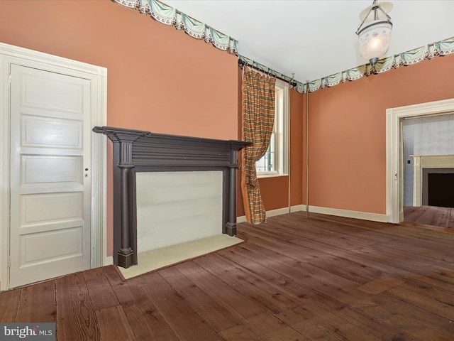 unfurnished living room with dark wood-type flooring