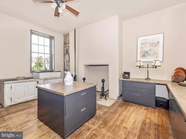 home office with ceiling fan, hardwood / wood-style floors, and sink