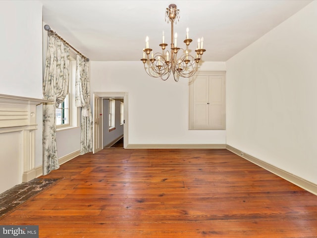 unfurnished dining area with wood-type flooring and a notable chandelier