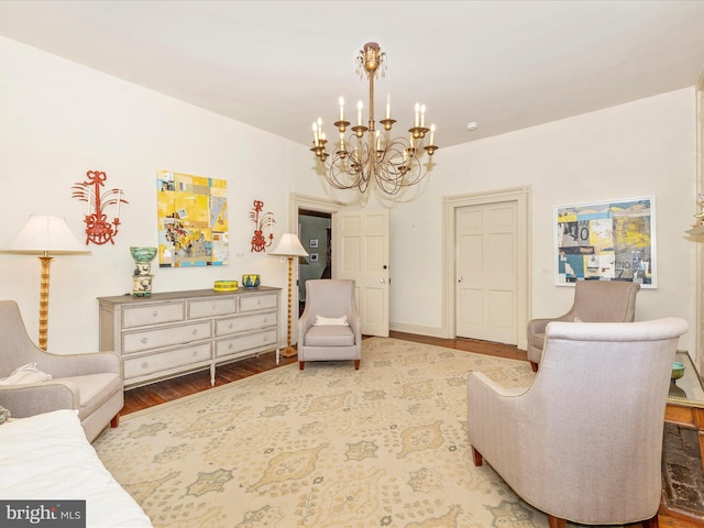 sitting room with an inviting chandelier and hardwood / wood-style floors