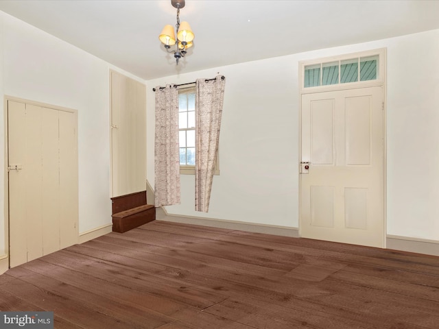 entryway featuring dark wood-type flooring and a notable chandelier