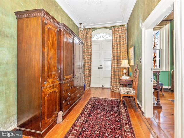 foyer entrance featuring crown molding and light hardwood / wood-style floors