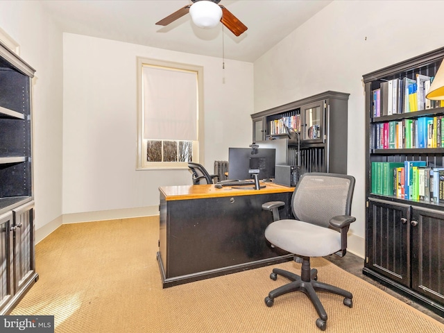 carpeted office featuring ceiling fan