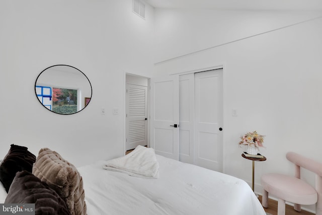 bedroom with hardwood / wood-style floors and high vaulted ceiling