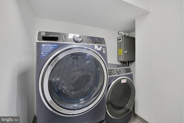 laundry room with tankless water heater and washing machine and clothes dryer