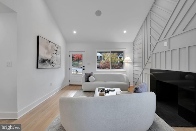 living room with light hardwood / wood-style floors and lofted ceiling