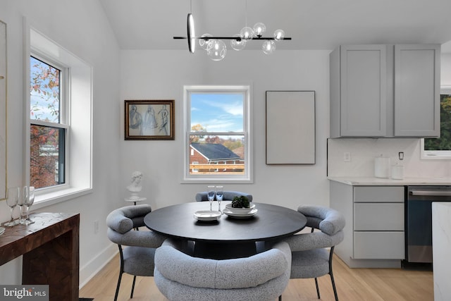dining space with a notable chandelier and light hardwood / wood-style floors