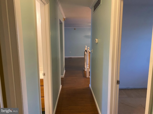 hallway with dark hardwood / wood-style flooring and ornamental molding