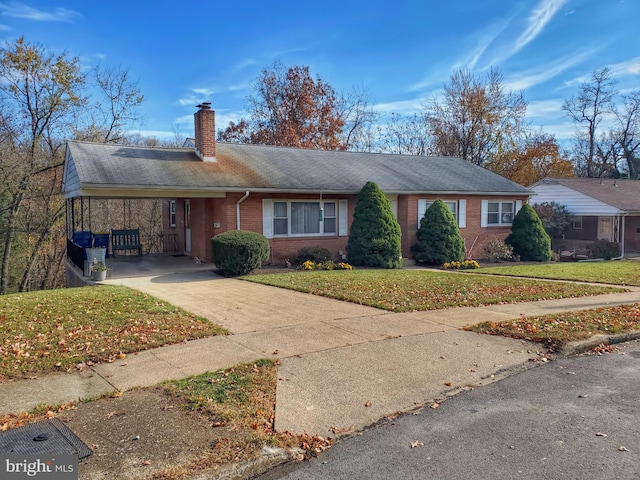 ranch-style home with a carport and a front lawn