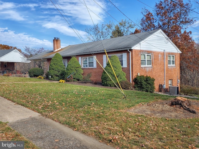 bungalow-style home with central AC unit and a front yard