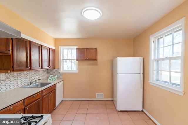 kitchen with white appliances, sink, a wealth of natural light, and tasteful backsplash