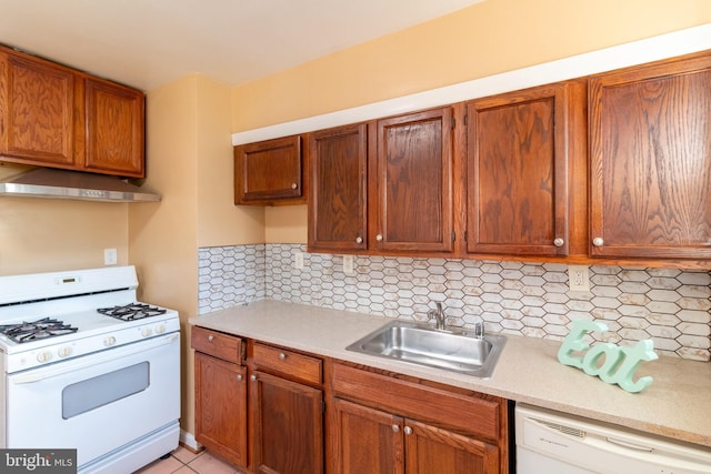 kitchen with decorative backsplash, sink, light tile patterned floors, and white appliances