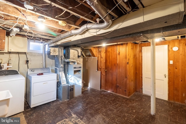 basement featuring separate washer and dryer and wood walls