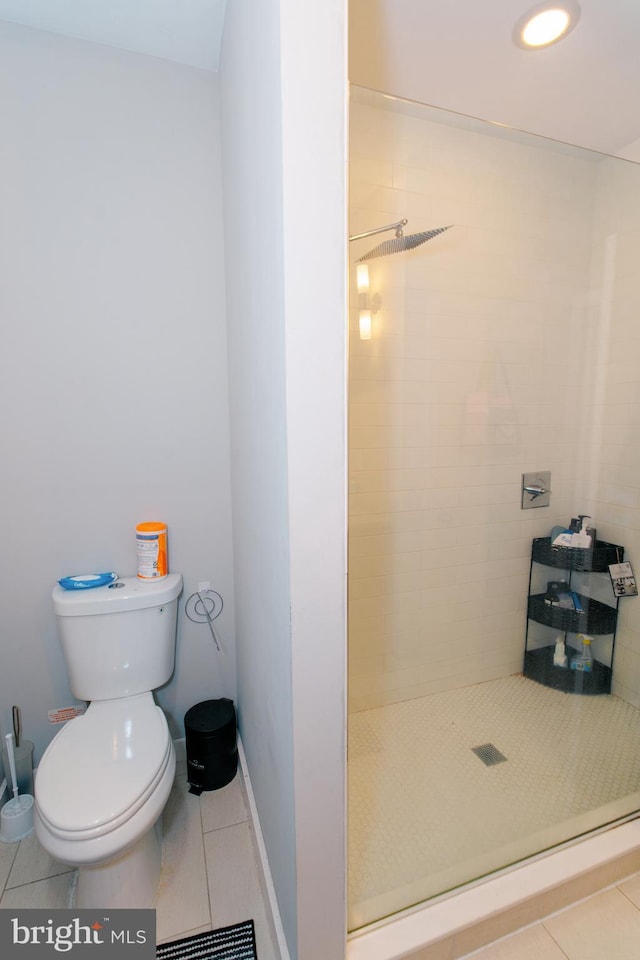 bathroom featuring tile patterned floors, toilet, and tiled shower