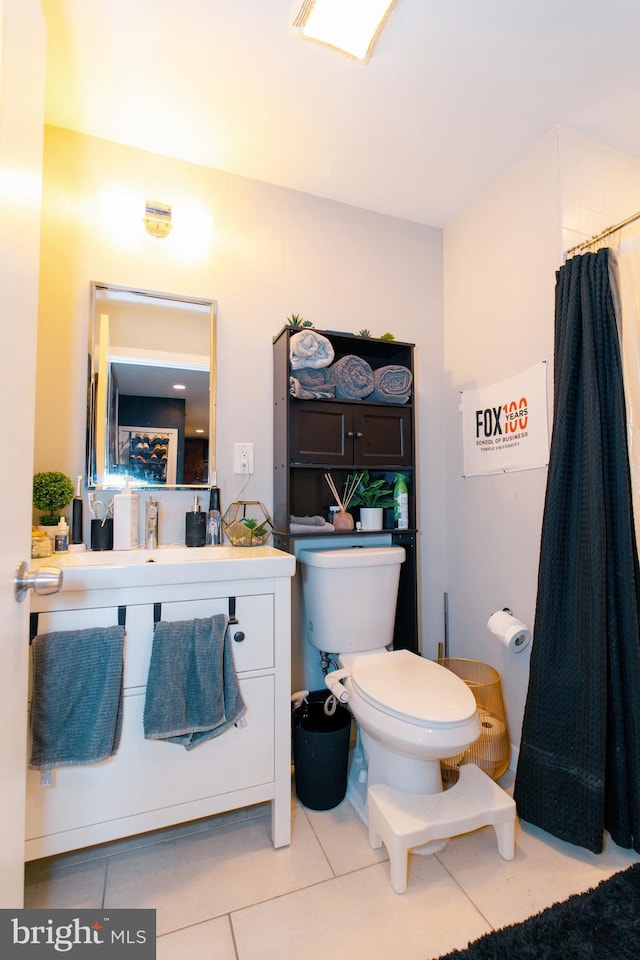 bathroom with tile patterned flooring, vanity, toilet, and walk in shower